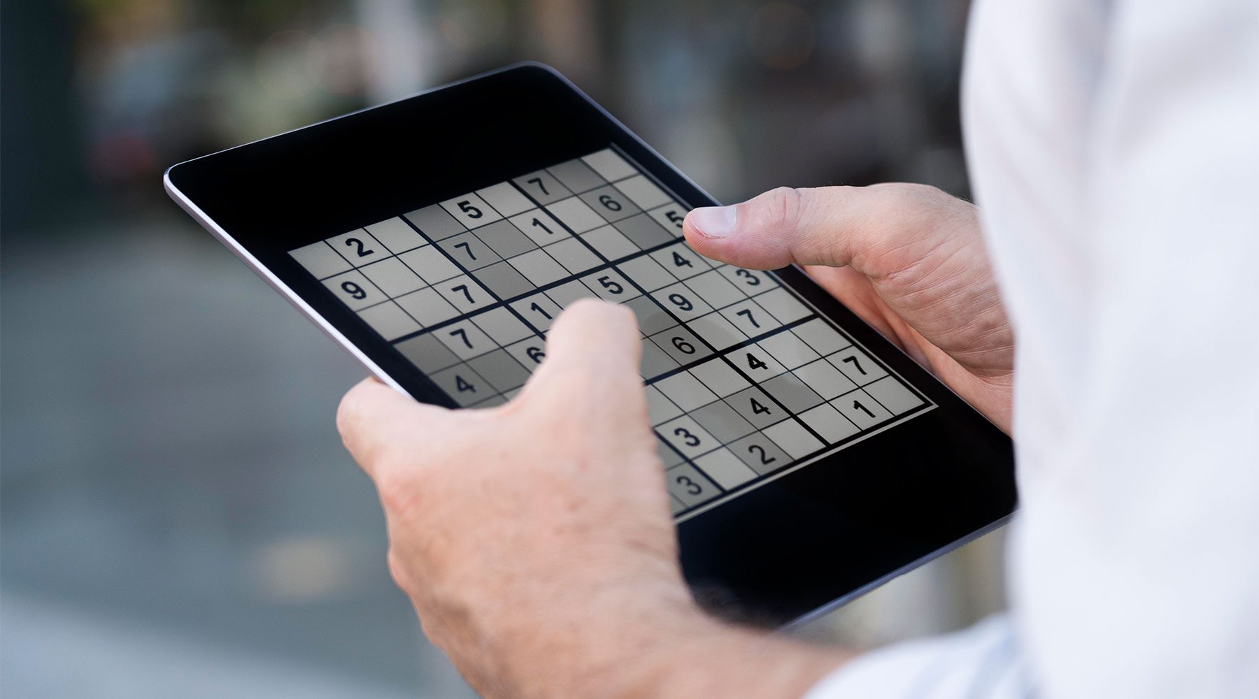 Anciano jugando a sudoku online, uno de los más demandados juegos para mejorar la memoria gratis.