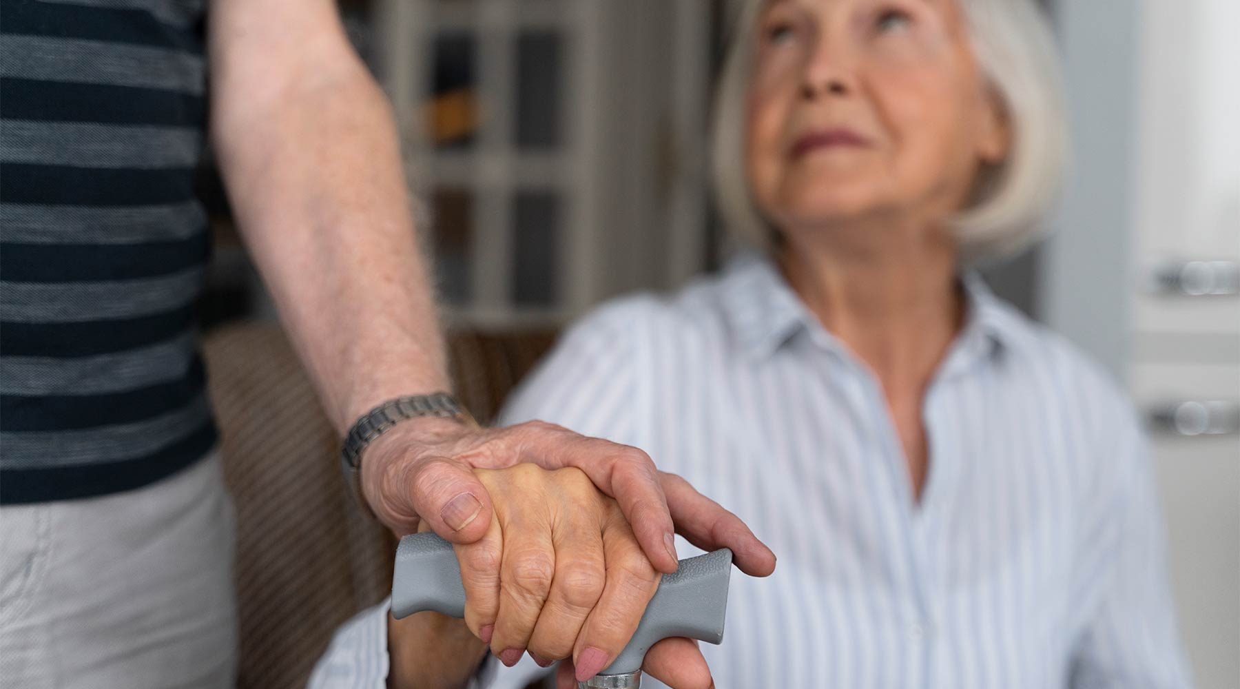 Cuidador de persona con Alzheimer apoyando en las tareas diarias.