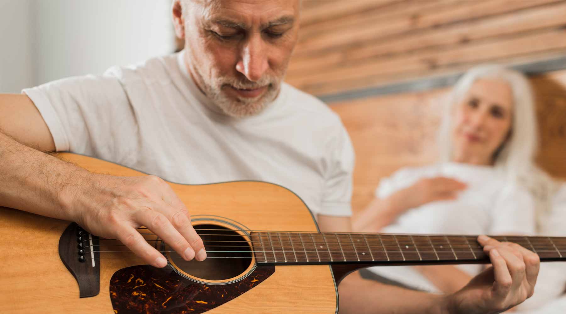 Anciano aprendiendo a tocar la guitarra.