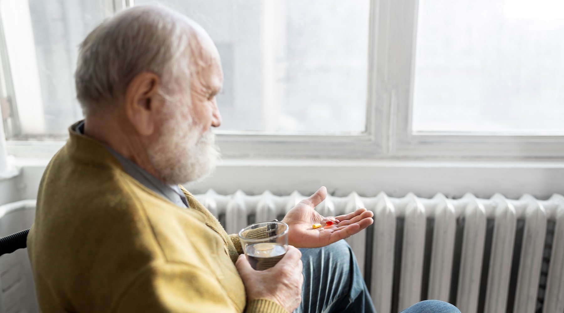 Anciano con Parkinson tomando medicación para la enfermedad.