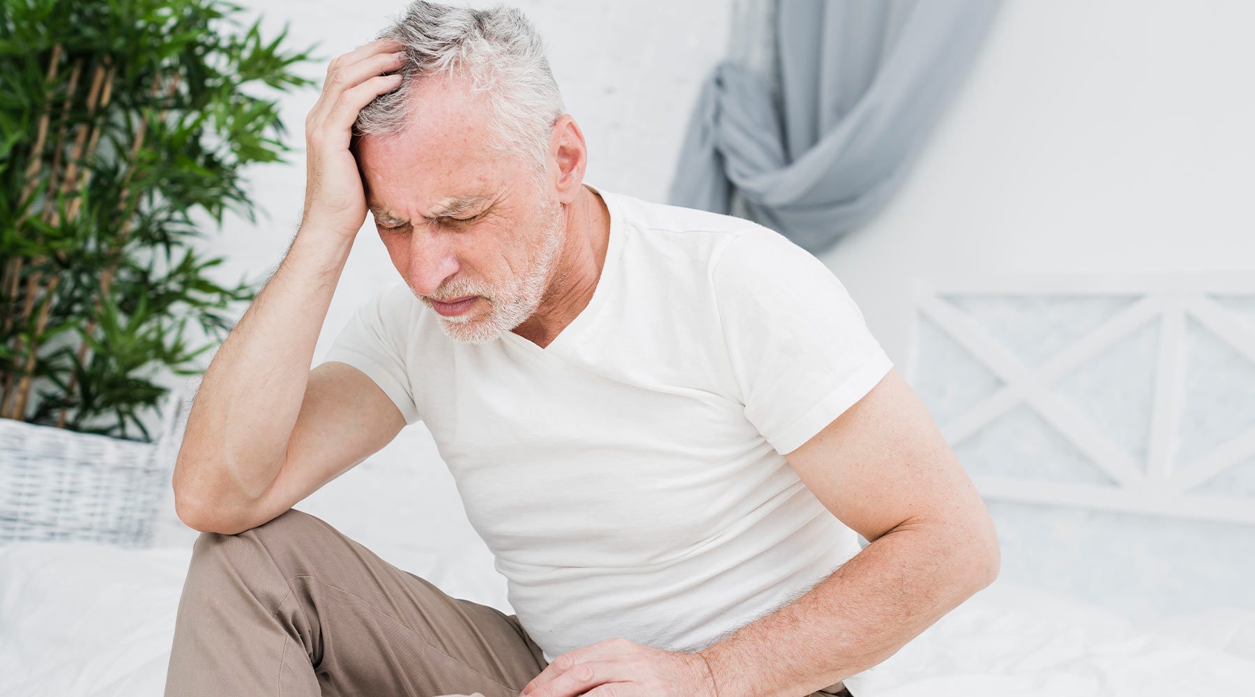 Anciano con fuerte dolor de cabeza síntoma común de fibromialgia.