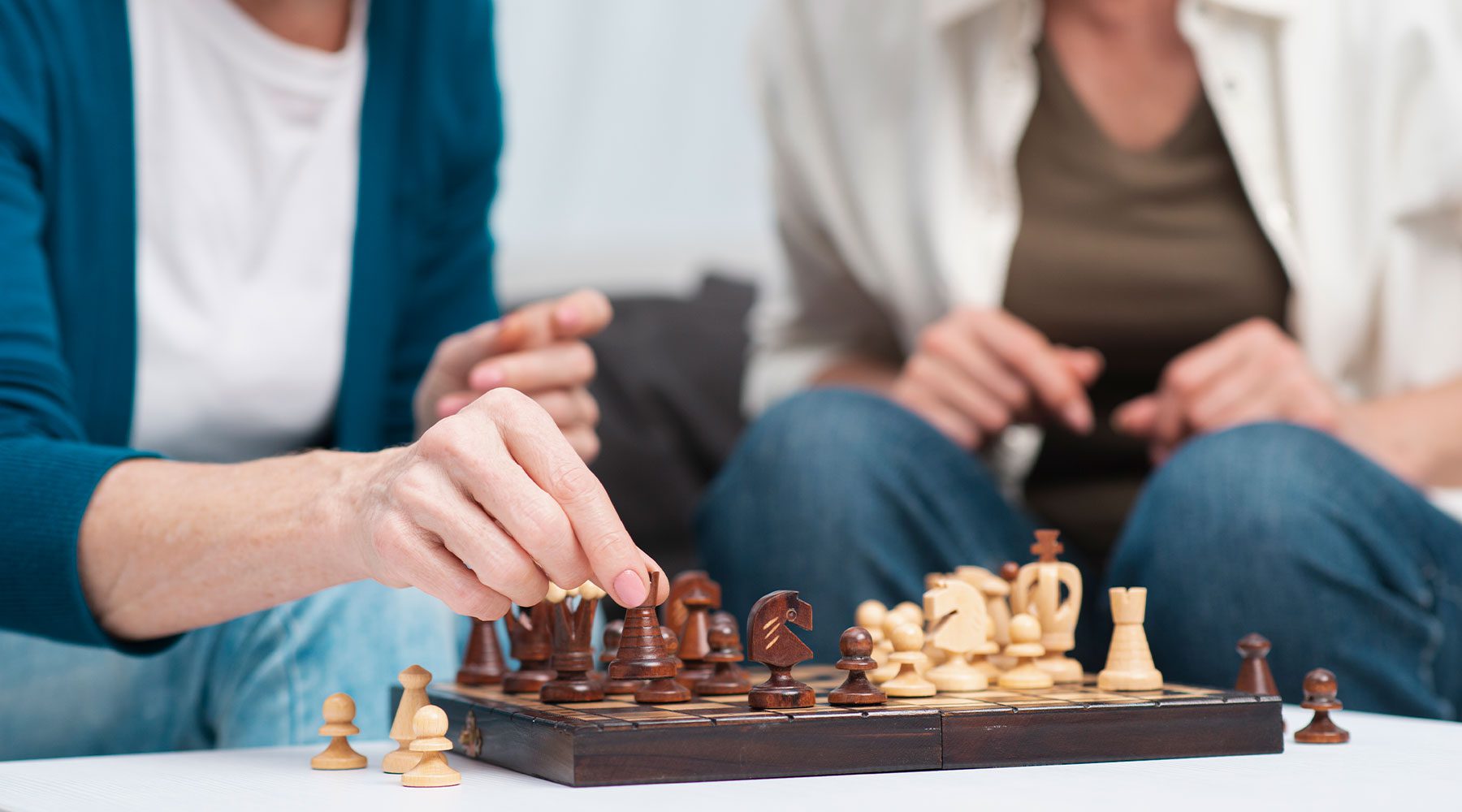 Personas mayores jugando una partida de ajedrez como actividad de estimulación cognitiva.