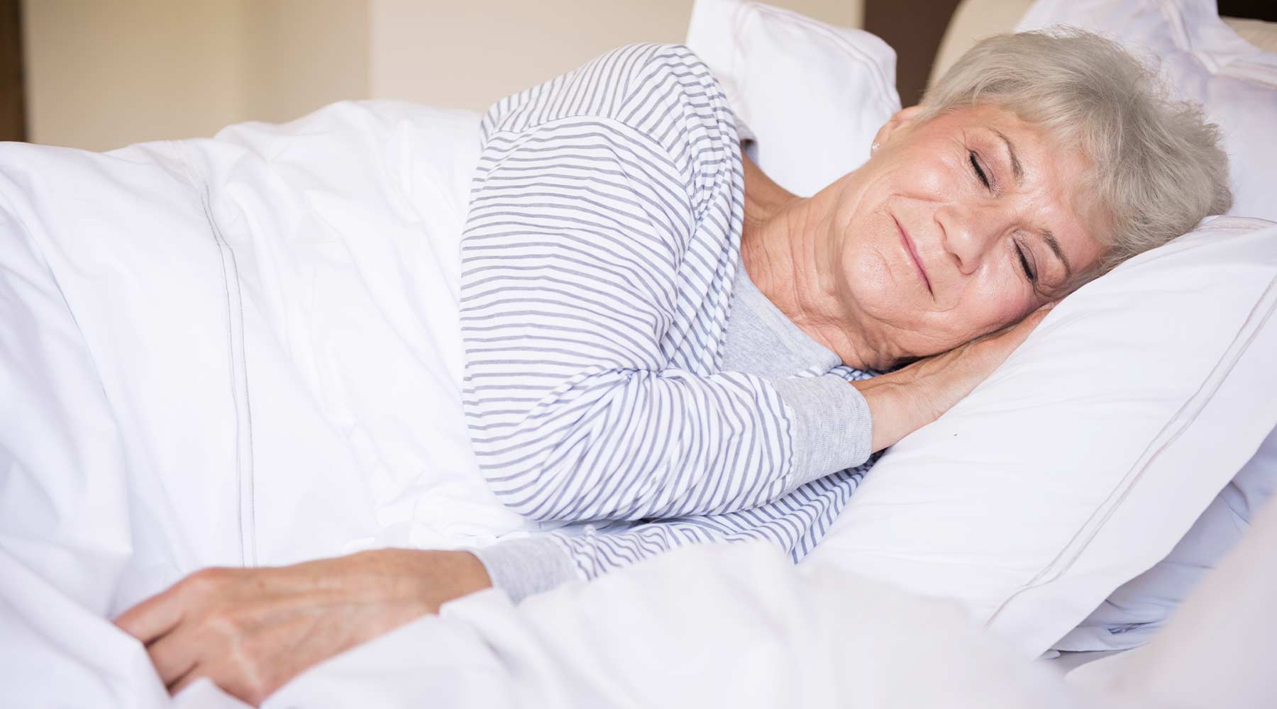 Anciana en su cama con exceso de sueño.
