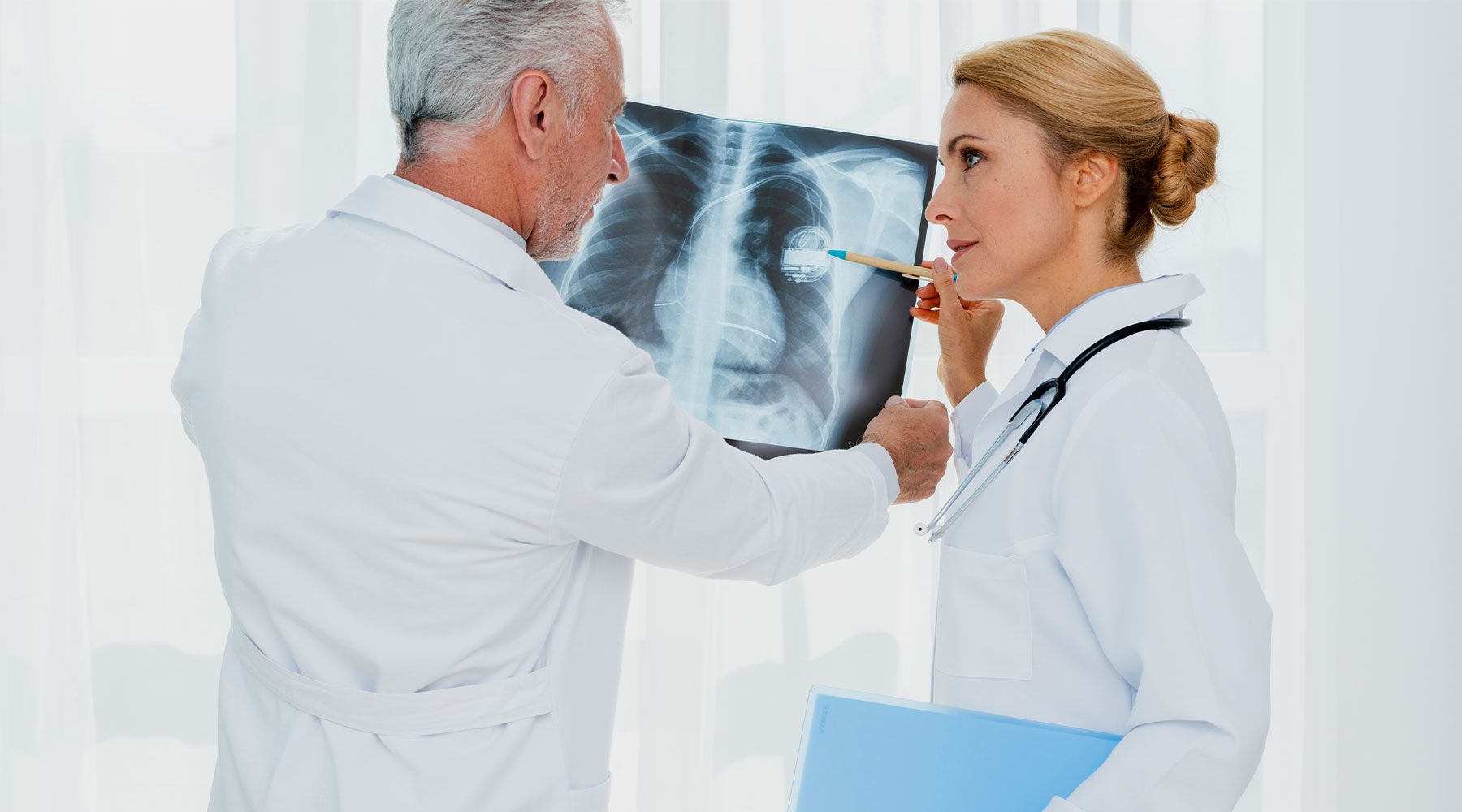 Doctores revisando radiografía de paciente con neumonía.